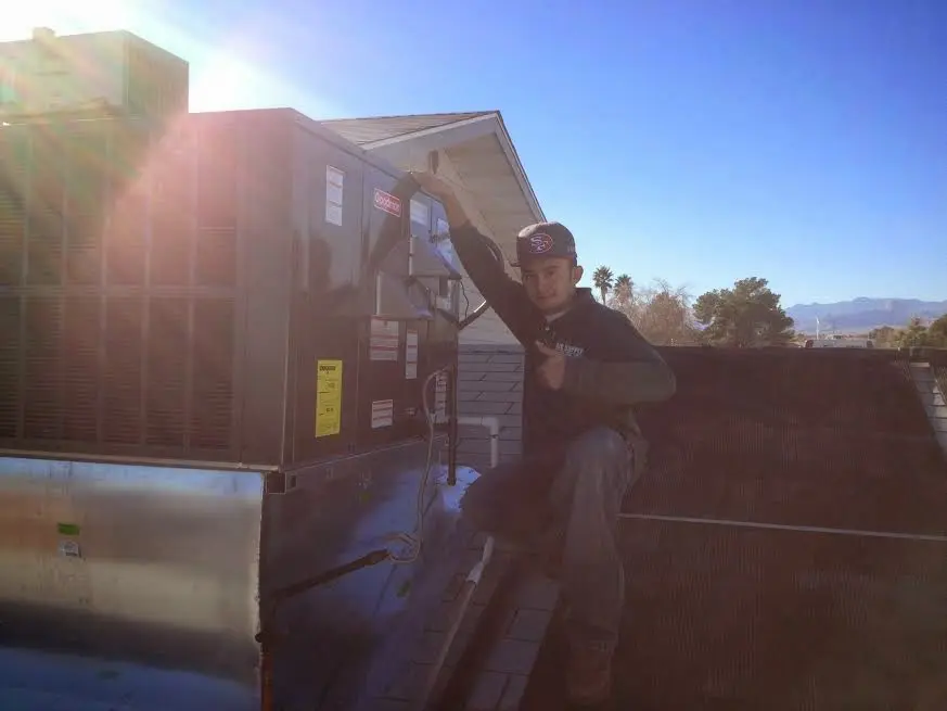 HVAC technician performing Air Duct Repair on a rooftop unit in Winter Springs